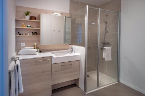a bathroom with a shower and a sink and a mirror at DOMITYS - La Palangre in Le Tréport