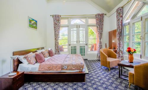 a bedroom with a bed and a table and a chair at Gaash Cottages in Buna Palang