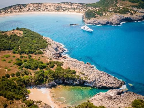 a boat in the water next to a beach at Charming Country House Just Steps from Everything in Kyparissia