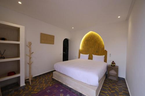 a bedroom with a large bed with a yellow headboard at Bohemian lodge guest house in Aït Namous