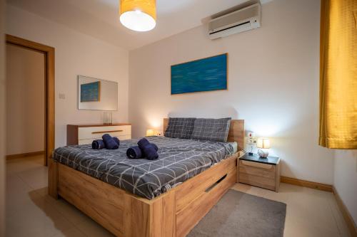 a bedroom with a bed with two blue pillows on it at Mellieha Bay 3 Bedroom Apartment ''Coastal Comfort'' in Mellieħa