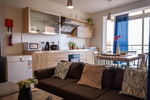 a living room with a couch and a kitchen at Mellieha Bay 3 Bedroom Apartment ''Coastal Comfort'' in Mellieħa