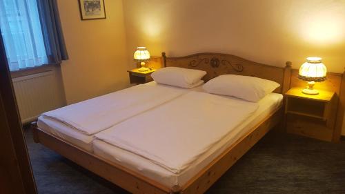 a bedroom with a bed with two lamps on two tables at Hotel Restaurant Krone in Bad Brückenau
