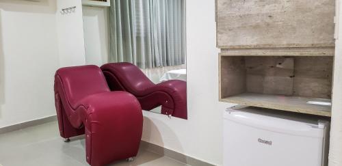 a pair of red chairs sitting in a room at Alpino Motel by Drops in Jundiaí