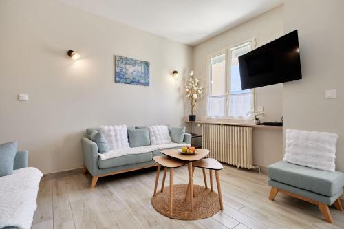 a living room with a couch and a table at La Parenthese - Charme & Coeur Historique in Bayeux