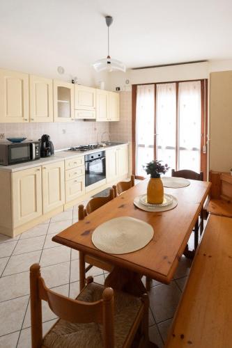 a kitchen with a wooden table and a table and chairs at A Due Passi dal Mare in Chioggia