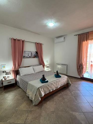 a bedroom with a bed with two cats sitting on it at Appartamento Rosa in Orosei