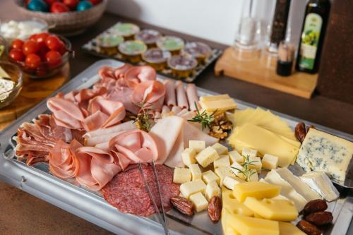 a tray of cheese and meats on a table at VENEZIANA Boutique Hotel Superior in Koper