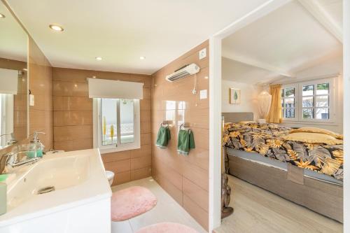 a bedroom with a bed and a tub and a sink at Casa Caro in Estepona
