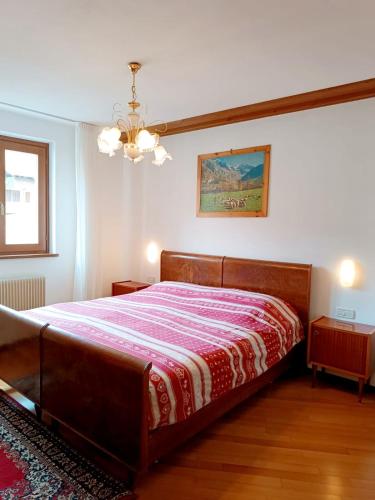 a bedroom with a bed with a red and white blanket at Dolomiti Alpine Homes - Appartamento Brenta in Giustino
