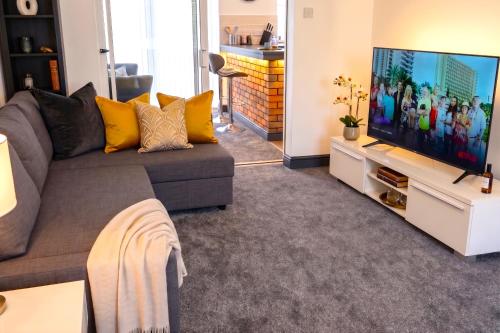 a living room with a couch and a flat screen tv at Green Haven Villa - 4BR Spacious House with Hot tub, Ample Parking, Air Condition, WIFI, Netflix, Patio & Garden in Oxford