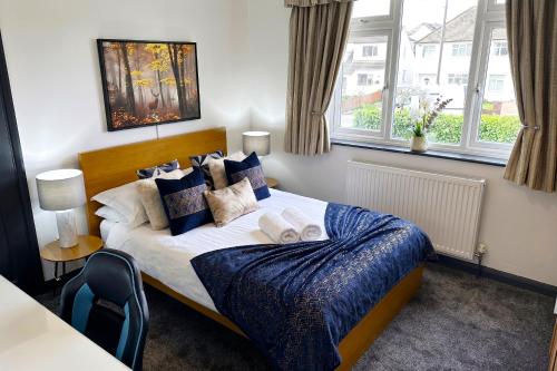 a bedroom with a bed with blue sheets and pillows at Green Haven Villa - 4BR Spacious House with Hot tub, Ample Parking, Air Condition, WIFI, Netflix, Patio & Garden in Oxford