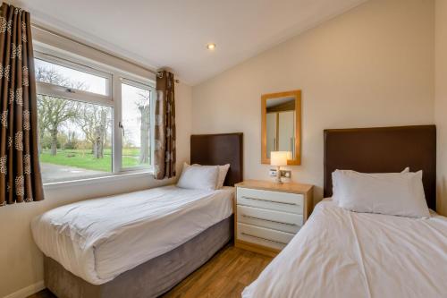 two beds in a room with a window at Field View 2 bed - Hazel in Eye