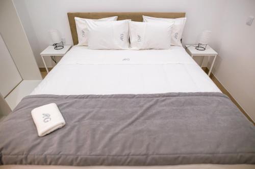 a bed with a white pillow and two night stands at Casa do Santo Estevão in Macedo de Cavaleiros