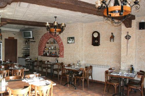 コルネリャー・デ・リョブレガートにあるHostal Restaurante Cornellaのテーブルと椅子、壁掛け時計のあるレストラン