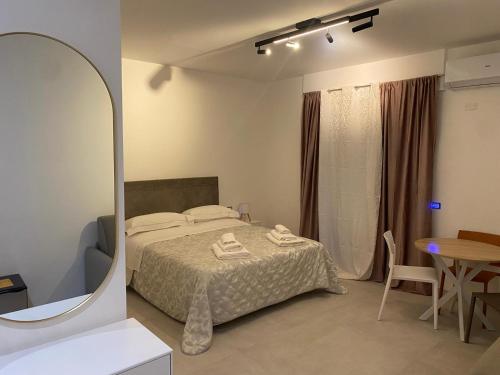 a bedroom with a bed and a mirror and a table at Kennedy rooms in Isernia