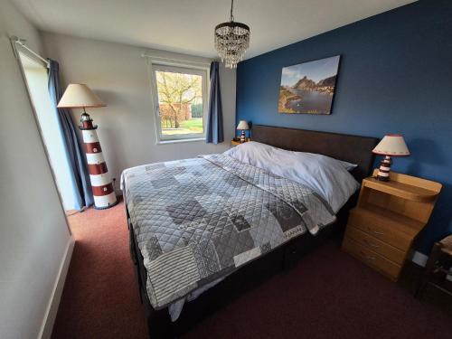 a bedroom with a bed and a blue wall at Gastenverblijf de Bloesem privé appartement in Lunteren
