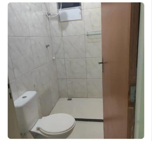 a small bathroom with a toilet and a shower at Casa Oliveira in Montes Claros