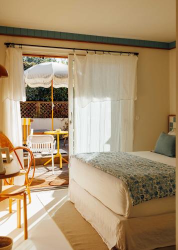 a bedroom with a bed and a patio at Hotel des Dunes in Cap-Ferret
