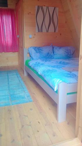 a bedroom with a bed in a wooden cabin at PROKLETIJE COTAGESEe in Plav