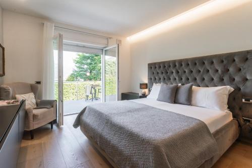 a bedroom with a large bed and a balcony at Villa Chiara in Stresa