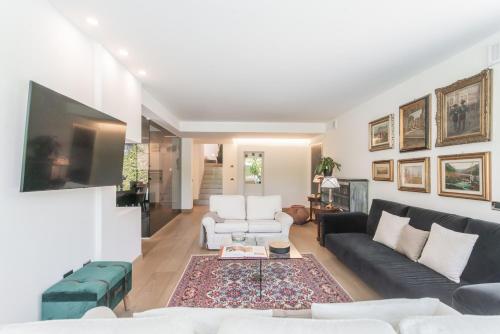 a living room with a couch and a tv at Villa Chiara in Stresa