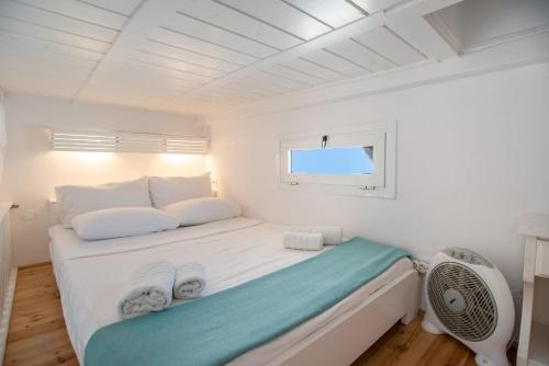 a white room with a bed and a window at Anna's Apartment Marmara Paros in Kampos Paros