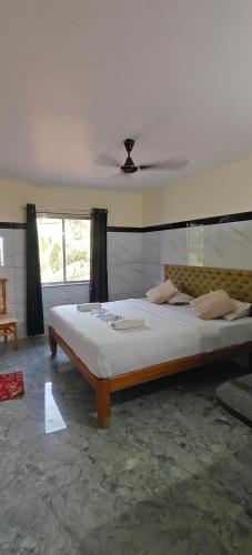 a bedroom with a large bed with a ceiling at Seaside Residency Murudeshwara in Māvalli