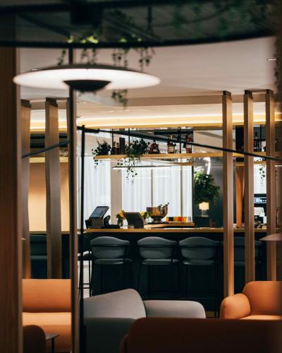 a bar in a restaurant with chairs and a counter at voco Malta by IHG in St. Julianʼs