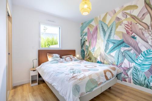 a bedroom with a bed with a tropical wallpaper at Maison neuve pmr proche plage in Concarneau