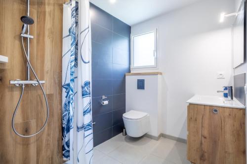 a bathroom with a shower and a toilet and a sink at Maison neuve pmr proche plage in Concarneau