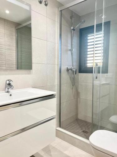 a bathroom with a shower and a sink and a toilet at Apartamentos Stella Maris in Roses