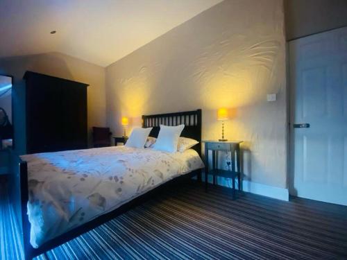 a bedroom with a bed with two tables and two lamps at 4 Bed in Derrylin oc-k35059 in Derrylin