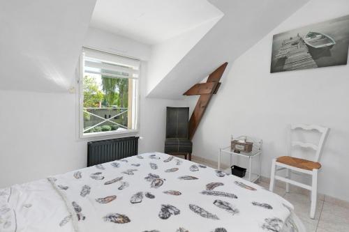 a white bedroom with a bed and a window at Chez Anne-Marie et Constant in Pornichet