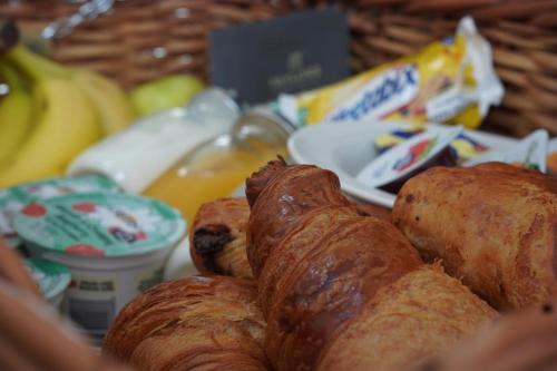 a basket filled with pastries and bananas and other foods at The Tollgate Hotel in Steyning