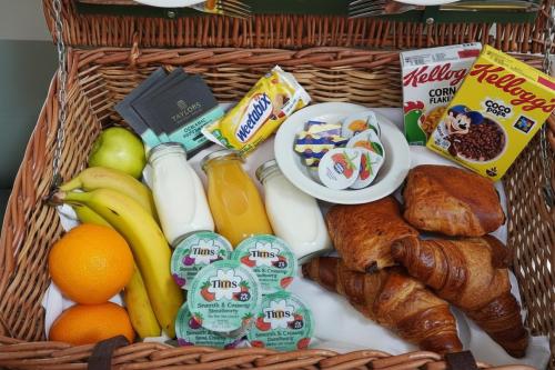 a basket full of breakfast foods including eggs fruit and bread at The Tollgate Hotel in Steyning