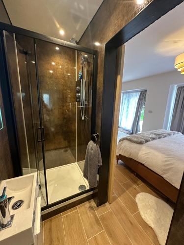 a bathroom with a shower and a bed in it at Longovers Lodge in Westbourne