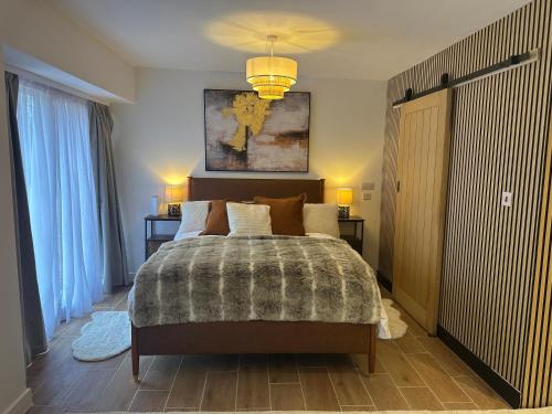 a bedroom with a large bed and a chandelier at Longovers Lodge in Westbourne