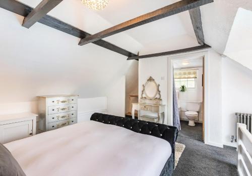 a bedroom with a bed and a bathroom at Beautiful Thatched Cottage with Outdoor Pool, Secure Garden, Dog & Family Friendly! Chichester Holiday Properties in Bosham