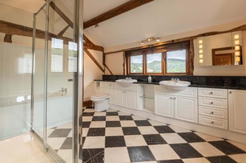 a bathroom with two sinks and a shower at Stud Farm House in Bleddfa