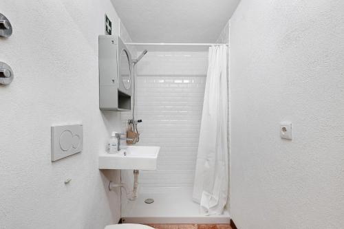 a white bathroom with a sink and a shower at Portas de Caminha I in Caminha