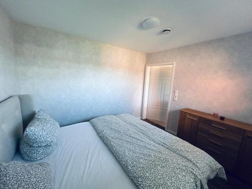 a bedroom with a bed and a dresser and a window at Ferienwohnung am Vechtedamm in Hoogstede