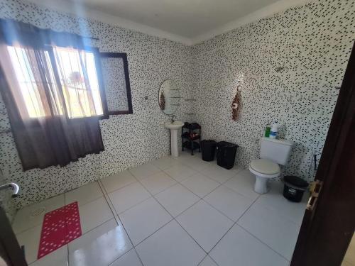 a bathroom with a toilet and a sink at Casa completa, Praia e Rio in Extremóz