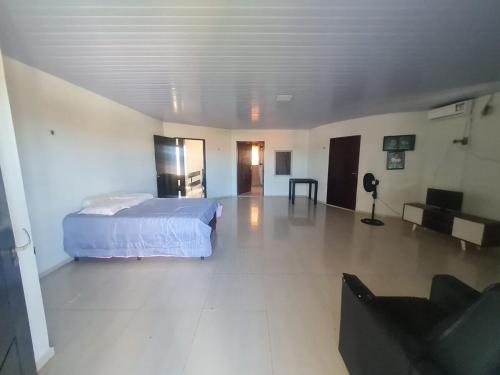 a bedroom with a bed and a living room at Casa completa, Praia e Rio in Extremóz