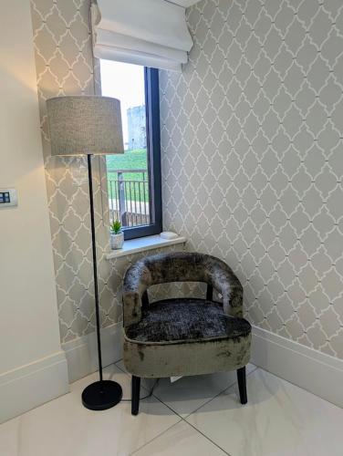 a chair in a room with a lamp and a window at The Old Fire Station Luxury Apartment in York