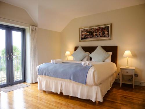 a bedroom with a large bed and a large window at Country Setting in the Middle of Dingle Town. in Dingle
