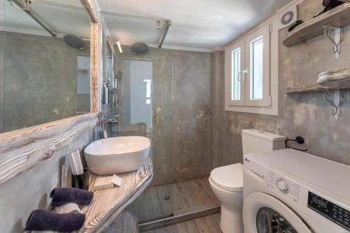 a bathroom with a sink and a washing machine at Zen Milos Green Apple in Pollonia