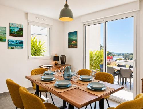 a dining room with a wooden table and chairs at La Maison des Falaises in Crozon
