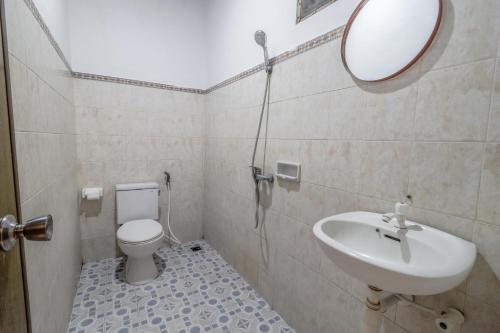 a bathroom with a sink and a toilet and a mirror at Komala Indah 2 in Badung