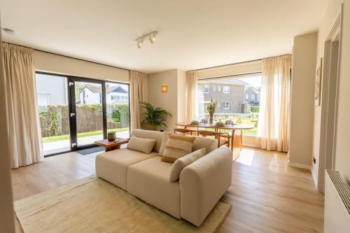 a living room with a couch and a table at Casiola - Charming Apartment with Garden & Parking in Cadzand